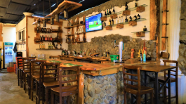 a bar with a stone wall and shelves of liquor bottles